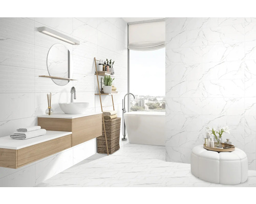 Baie modernă cu gresie de marmură albă pe pereți și podea, lavoar cu oglindă și cadă.