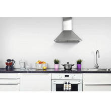 Bucătărie luminoasă cu chiuvetă, plită, cuptor, hotă și ustensile de bucătărie pe blat.