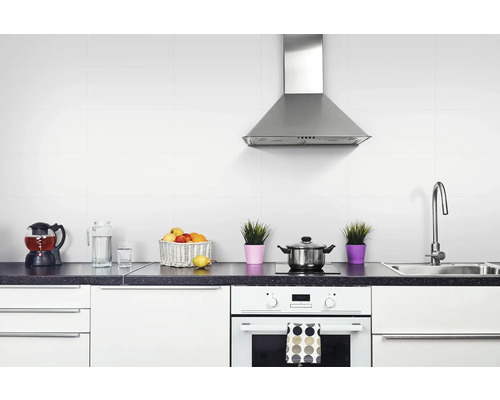 Bucătărie luminoasă cu chiuvetă, plită, cuptor, hotă și ustensile de bucătărie pe blat.