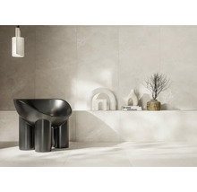 Cameră luminoasă cu podea cu gresie, perete cu gresie, lampă de design și fotoliu modern