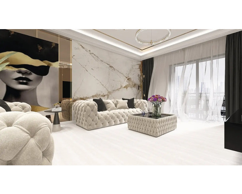 Living luxos și luminos cu canapea capitonată crem, perete aspect marmură, tablou modern și ferestre mari cu perdele transparente.