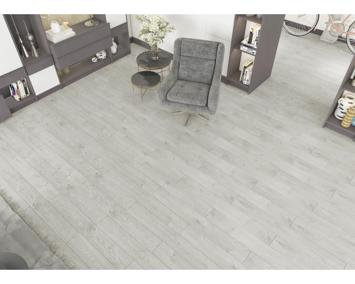 Sufragerie modernă cu pardoseală laminată gri deschis cu aspect de lemn, un fotoliu gri, măsuțe laterale mici și rafturi încorporate.