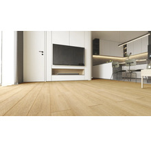 Spațiu de locuit modern cu pardoseală deschisă cu aspect de stejar, unitate de perete albă cu televizor și bucătărie deschisă în fundal.