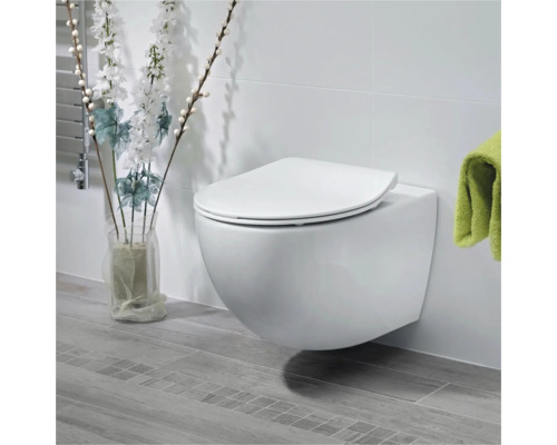 Toaletă suspendată cu capac în baie luminoasă.