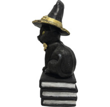 Figurină decorativă pisică neagră cu pălărie de vrăjitoare pe o grămadă de cărți