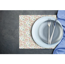 Suport pentru farfurii cu model floral, două farfurii și tacâmuri pe o suprafață închisă și texturată.