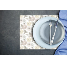 Set de masă cu model floral, decorat cu farfurii, tacâmuri și un șervețel pe un fundal întunecat.