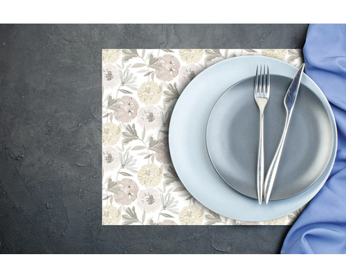 Set de masă cu model floral, decorat cu farfurii, tacâmuri și un șervețel pe un fundal întunecat.