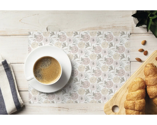 Suport de farfurie cu model floral pe o masă din lemn cu o ceașcă de cafea și cornuri pe un tocător de lemn.