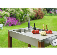 Bucătărie de exterior cu chiuvetă, robinet, legume, șampanie și suport pentru prosoape de hârtie în grădină