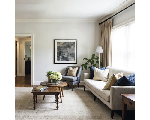 Living cu canapea, fotoliu, măsuță de cafea și operă de artă