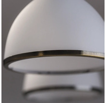 Prim-plan cu o lampă suspendată albă cu inel metalic