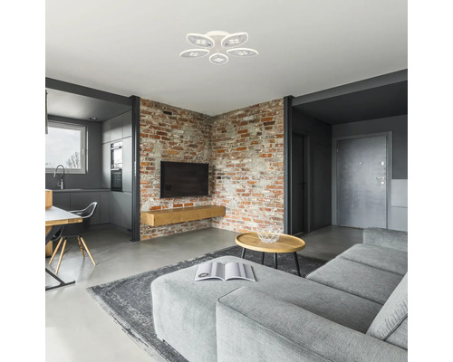 Living modern cu perete de cărămidă, canapea gri, masă și plafonieră albă