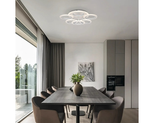 Sufragerie cu masă de dining, scaune și plafonieră rotundă cu mai multe inele