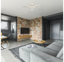 Cameră de zi cu perete de cărămidă, canapea și plafonieră circulară