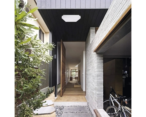 Intrarea într-o casă cu iluminat, ușă și biciclete