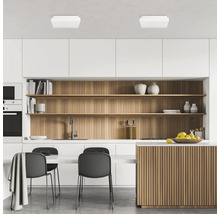 Bucătărie modernă cu dulapuri albe, rafturi din lemn și corpuri de iluminat de tavan