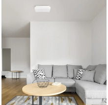 Cameră de zi cu canapea de colț gri, măsuță de cafea și lampă de plafon