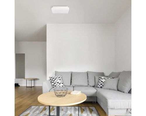 Cameră de zi cu canapea de colț gri, măsuță de cafea și lampă de plafon