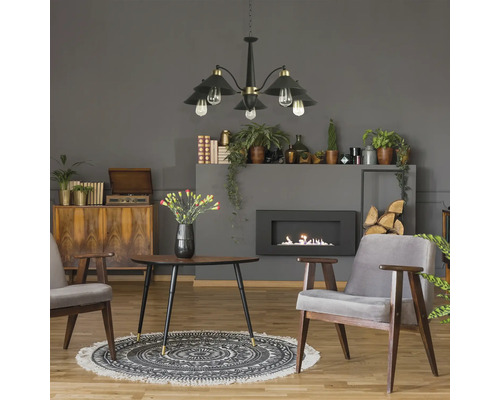 Cameră de zi cu șemineu, lampă suspendată, fotolii, masă și decorațiuni