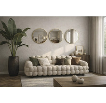 Cameră de zi cu canapea tapițată, perne decorative, plantă de interior într-un ghiveci și trei oglinzi rotunde pe perete.