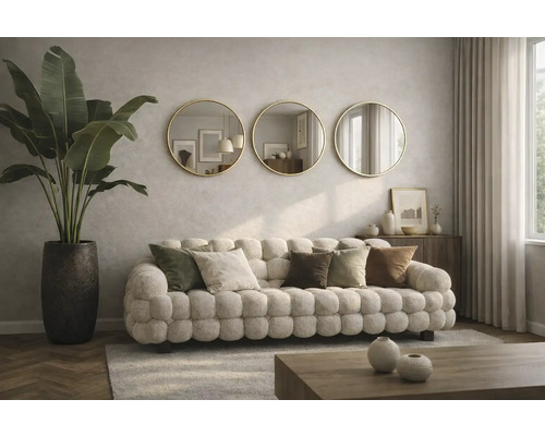 Cameră de zi cu canapea tapițată, perne decorative, plantă de interior într-un ghiveci și trei oglinzi rotunde pe perete.