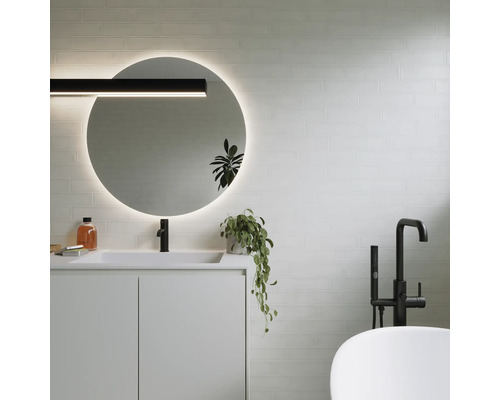 Baie modernă cu oglindă rotundă, chiuvetă, robinet și cadă.