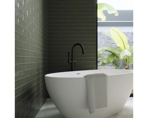 Baie modernă cu faianță verde, cadă independentă și baterie neagră