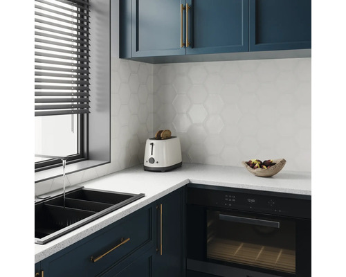 Bucătărie modernă cu chiuvetă, prăjitor de pâine, cuptor și faianță hexagonală.