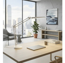 Birou luminos cu birou, lampă de birou, laptop, plantă și fereastră cu vedere la oraș