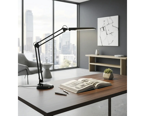 Birou cu lampă de birou cu braț mobil, carte și pixuri într-un birou luminos.