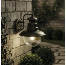 Lampa de perete pentru exterior cu glob de sticlă pe un zid de piatră