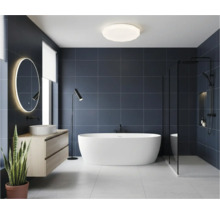 Baie modernă cu cadă freestanding, chiuvetă și oglindă iluminată