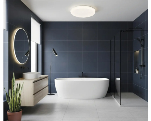 Baie modernă cu cadă freestanding, chiuvetă și oglindă iluminată