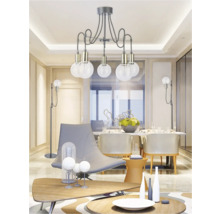 Living cu lampă suspendată, fotolii și masă de sufragerie pentru o atmosferă luminoasă și spațioasă.