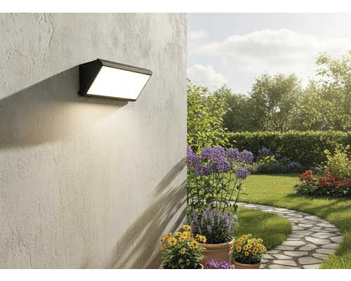 Perete exterior cu lampă de perete cu LED montată într-o grădină