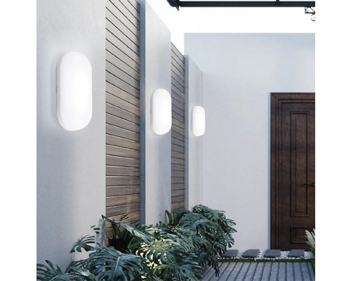 Exterior cu trei lumini de perete albe pe un perete