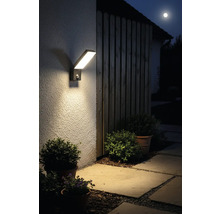 Lumină modernă de exterior cu LED, cu senzor de mișcare pe un perete al casei pe timp de noapte