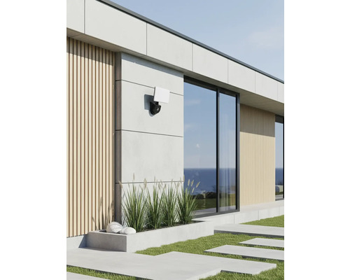 Exteriorul unei case moderne cu o lampă de exterior pe fațadă