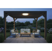 Pergolă cu mobilier de grădină, plafonieră și ghirlandă luminoasă în grădină la amurg.
