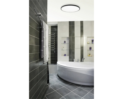 Baie modernă cu cadă, radiator pentru prosoape și gresie gri