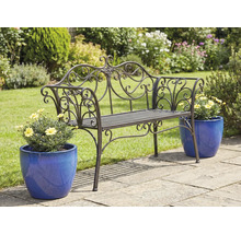 Bancă de grădină metalică ornamentată cu ghivece de flori pe o terasă de grădină