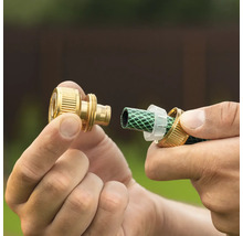 Montarea unui conector de furtun din alamă pe un furtun de grădină verde.