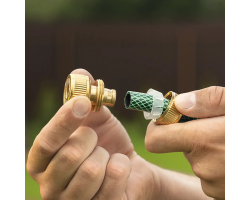 Montarea unui conector de furtun din alamă pe un furtun de grădină verde.