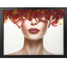 Tablou de perete cu portretul unei femei, ochii acoperiți de mușchi colorat și petale, în ramă neagră.