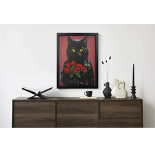 Tablou modern înrămat cu o pisică neagră în jachetă de piele și flori deasupra unei comode închise la culoare cu obiecte decorative.