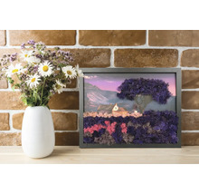 Tablou din mușchi stabilizat cu peisaj, casă și copac în ramă neagră, pe o poliță de lemn lângă vază cu flori în fața unui perete de cărămidă.