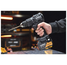 Mașină de găurit și înșurubat neagră DeWalt 18 Volt McLaren Formula 1 Team Special Edition ținută de o mână într-un atelier.