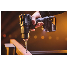 Mașină de găurit și înșurubat cu acumulator DeWALT Special Edition găurind o grindă de lemn.