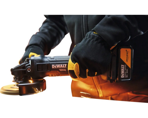 O persoană utilizează un polizor unghiular DeWalt ediție specială cu scântei luminoase. Acumulator 18 Volți și 5 Amperi-oră.